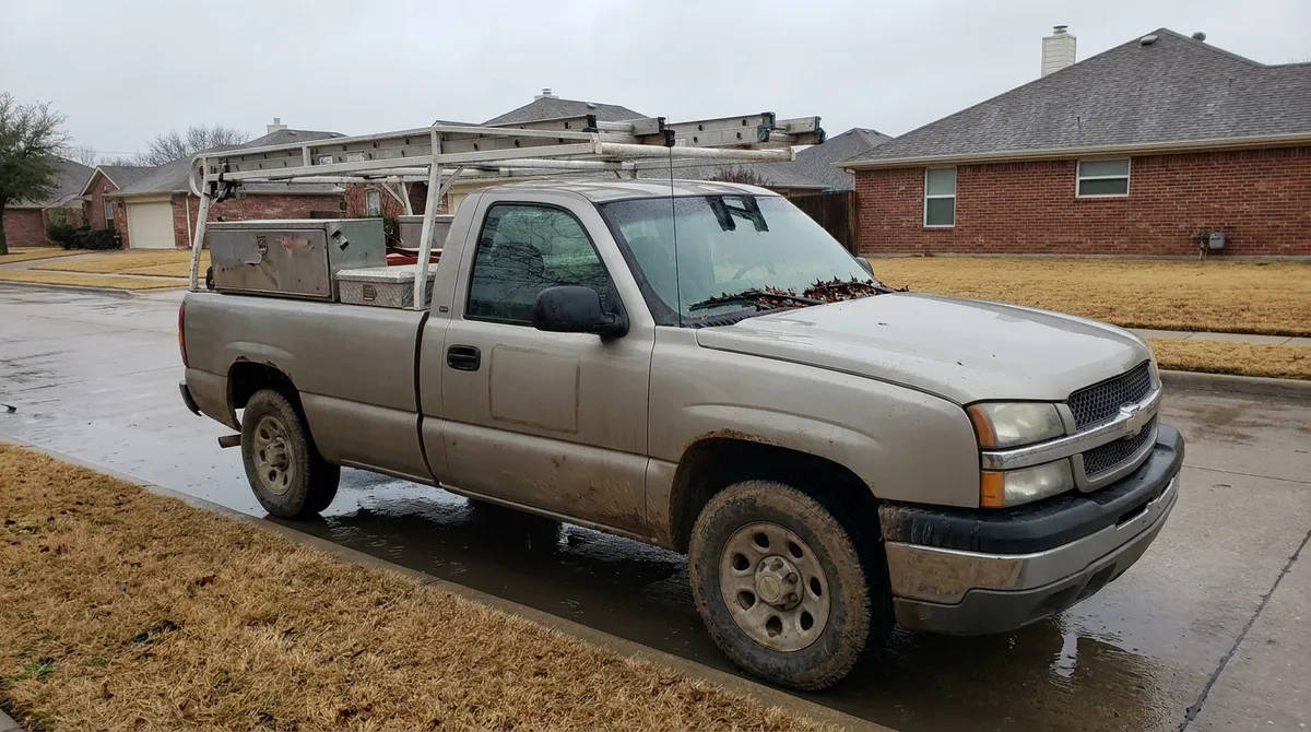 A box truck with out-of-state license plates parked on a North Texas residential street after a hailstorm