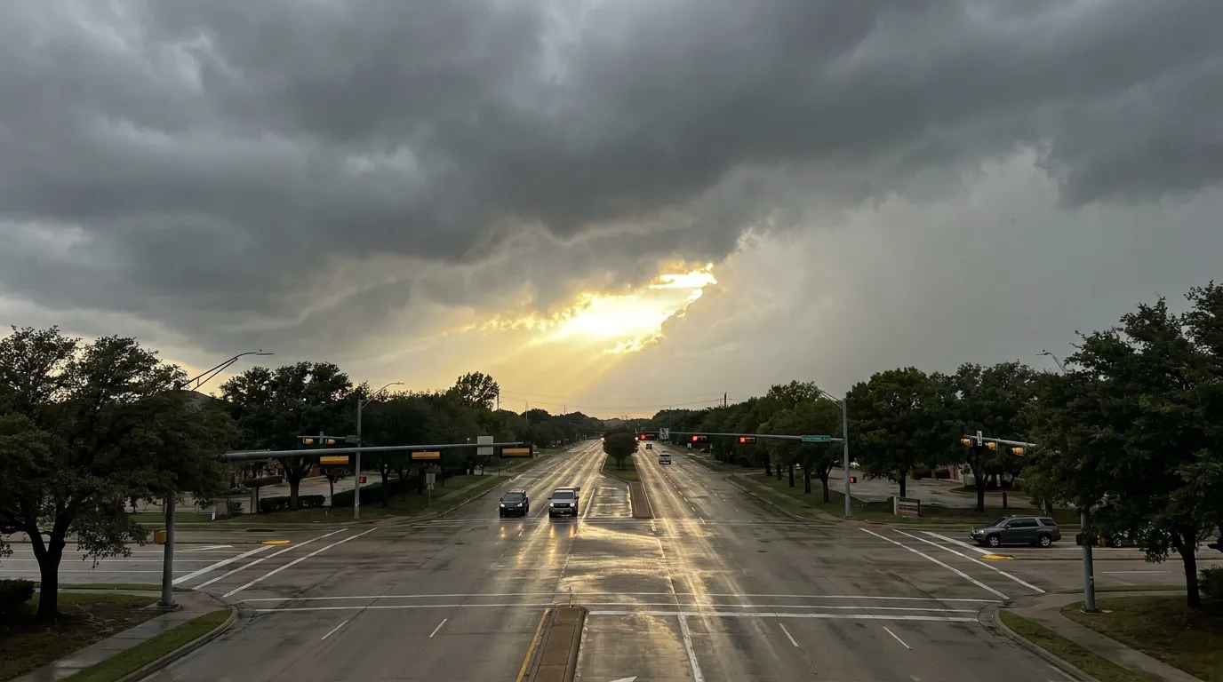 Wide suburban North Texas arterial road corridor lined with mature trees under a storm sky