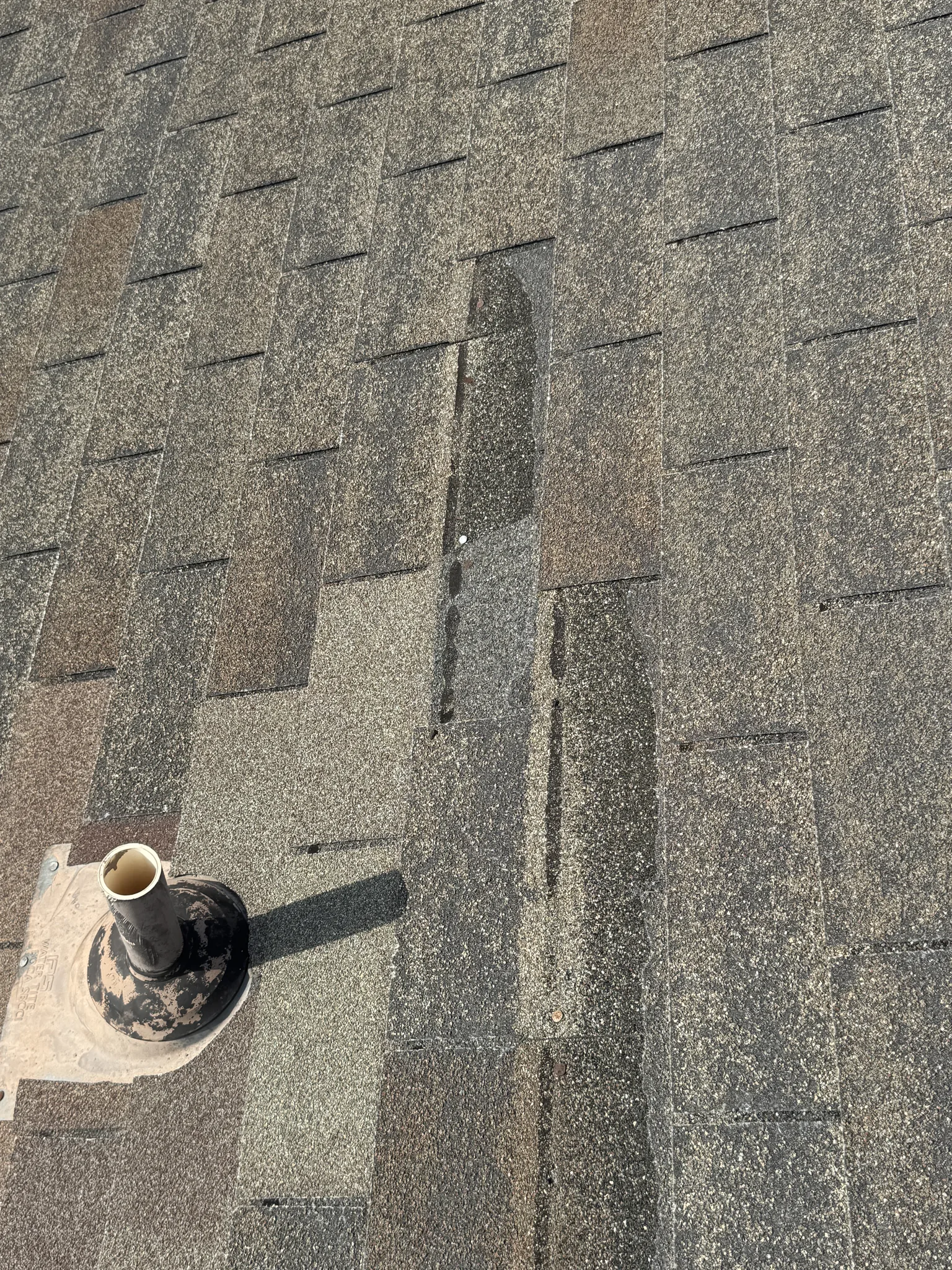 A weathered pipe boot and vent stack penetration on an asphalt shingle roof, a common roof leak entry point Roof Raiders traces in Dallas
